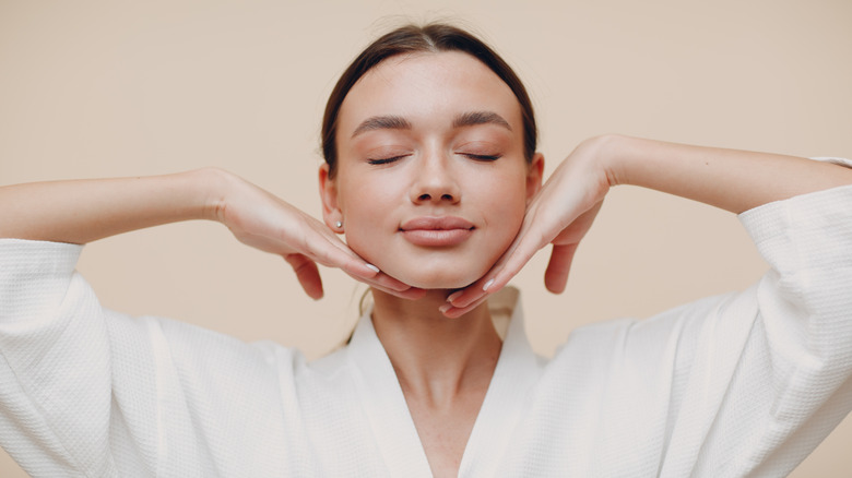 woman massaging jawline