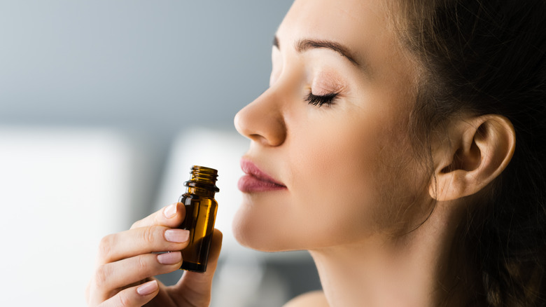Woman sniffs an essential oil 