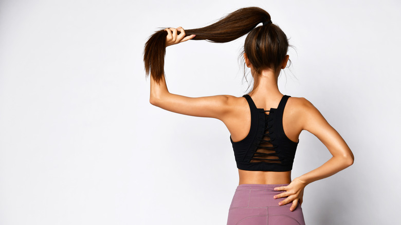 girl in workout clothes holding hair