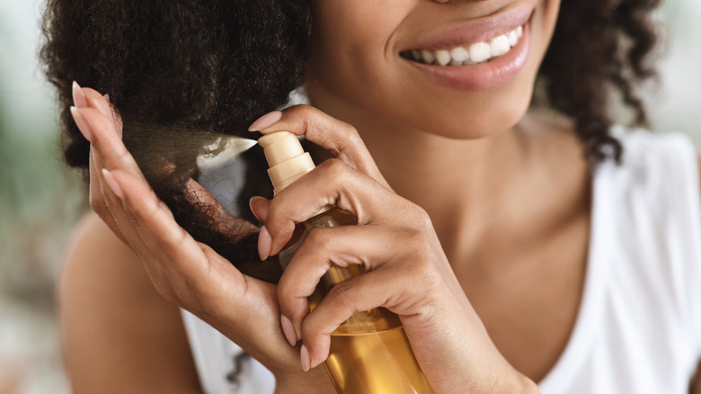 curly haired woman applying serum