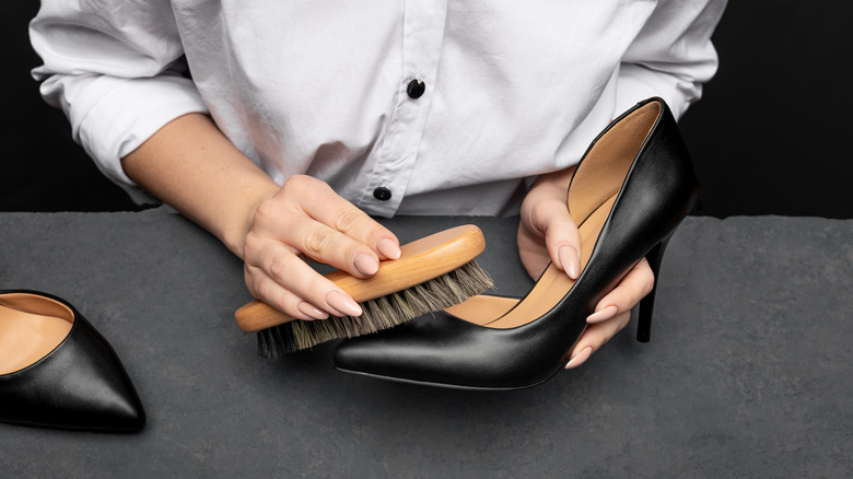 woman cleaning patent leather shoes