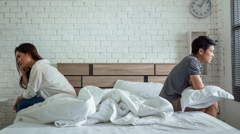 Couple facing apart in bed