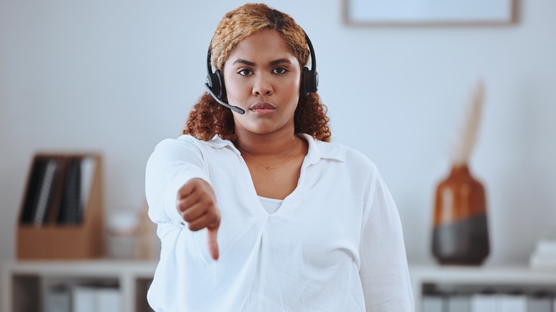 Woman holding her thumb down