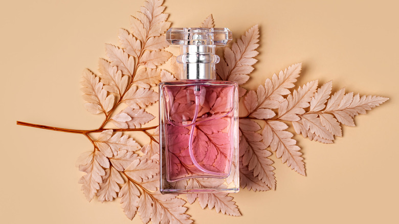 Perfume bottle on leaf background
