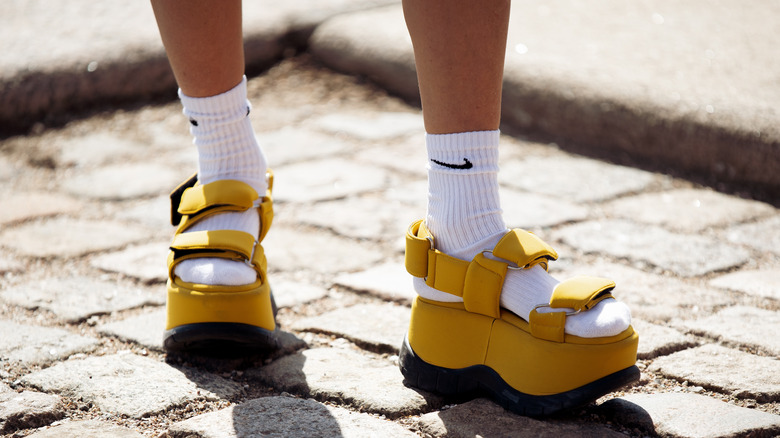 Yellow sandals with Nike socks