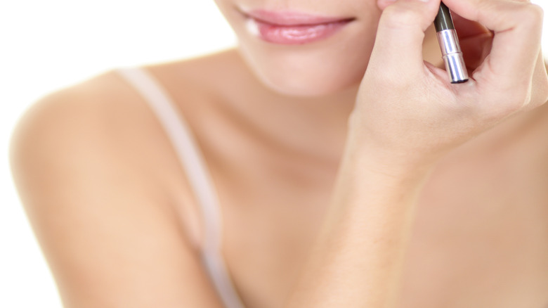 A woman applying eyeliner