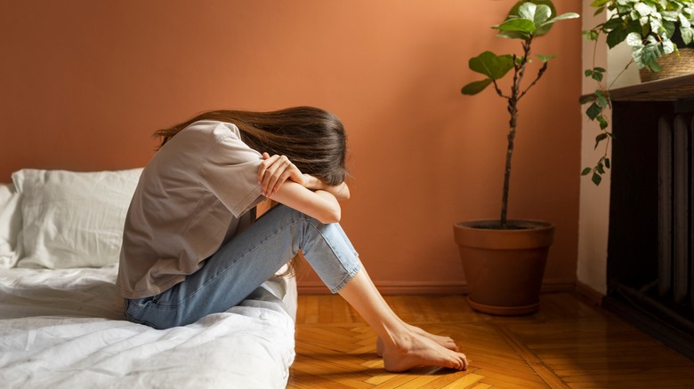 Woman hiding head in arms