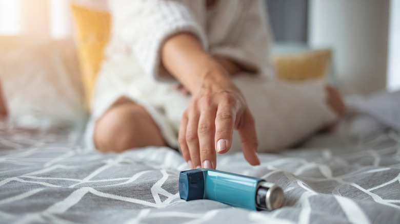 Person reaching for an inhaler