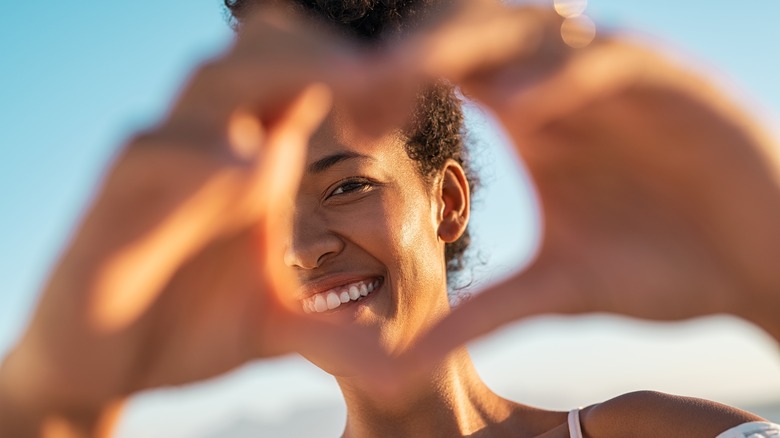 woman with hands making heart