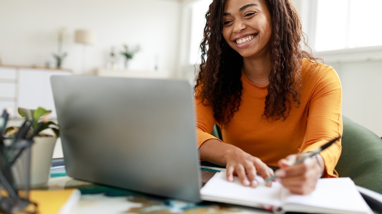 Woman working and writing at home