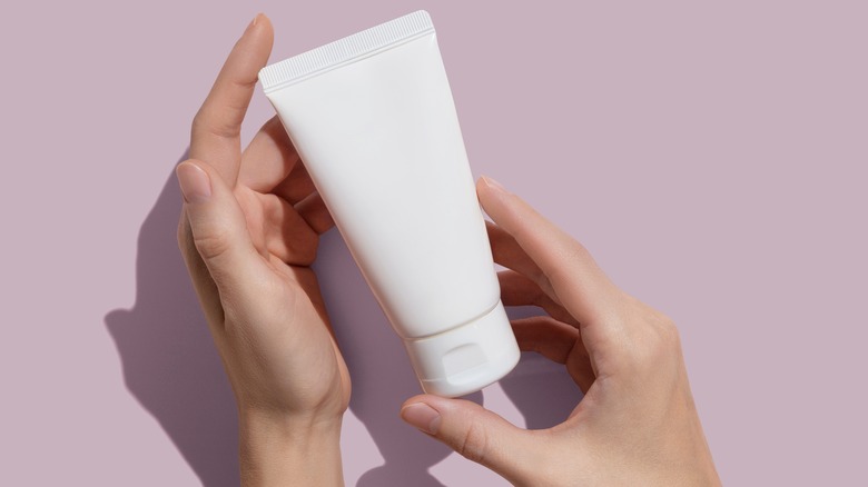 Hands holding skincare bottle