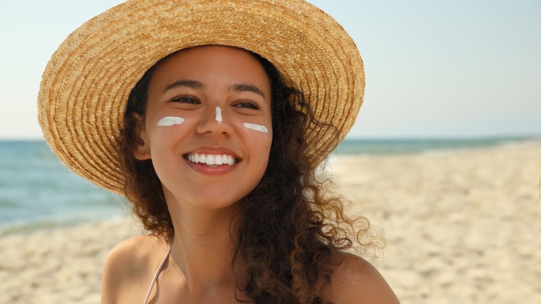 Woman at beach sunscreen under eyes