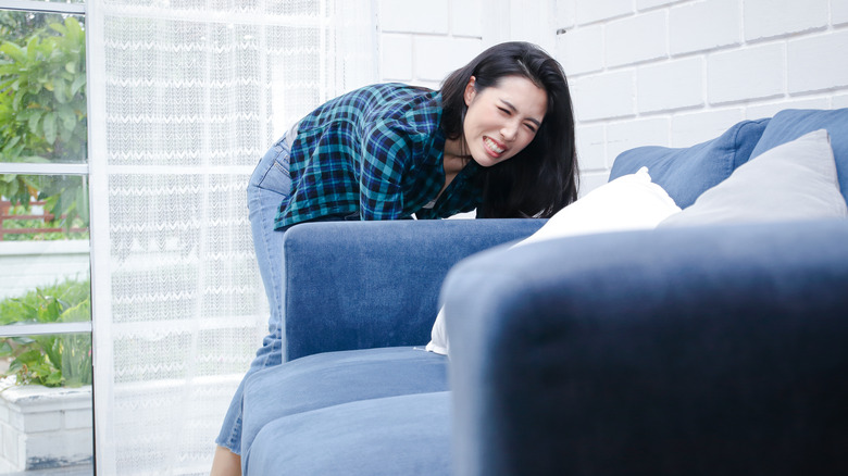 person struggling to lift furniture