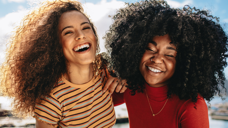 friends with curly hair laughing