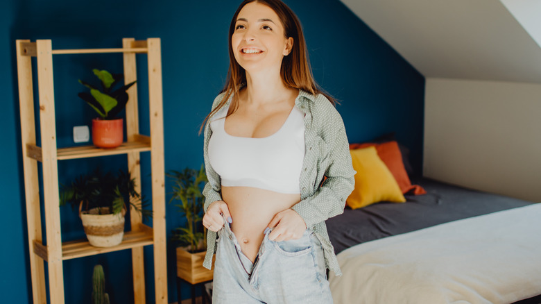 woman putting on jeans