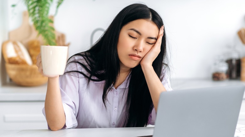 sleep-deprived woman holding mug