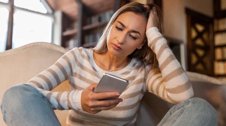 woman looking skeptical on phone