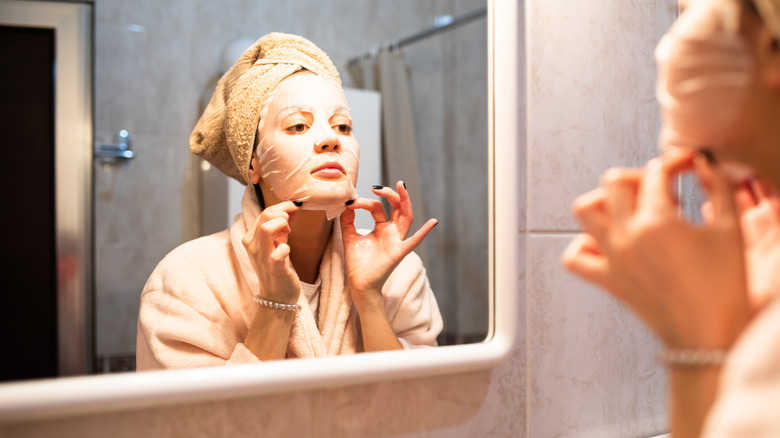 Woman applying sheet mask