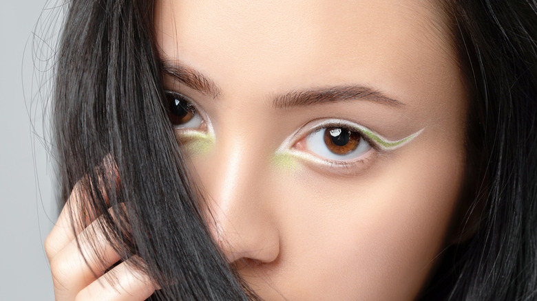 Girl with bright eyeliner in white and green