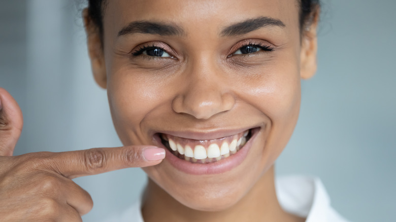 girl holding toothbrush brushing her teeth