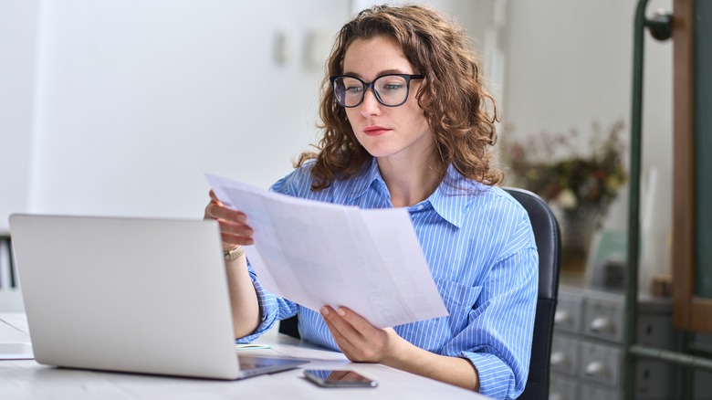 Woman sitting at desk looking at papers