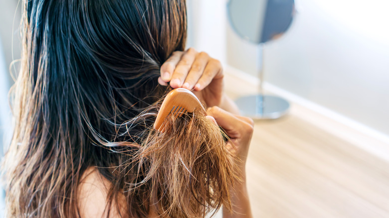 Woman brushing knotty hair