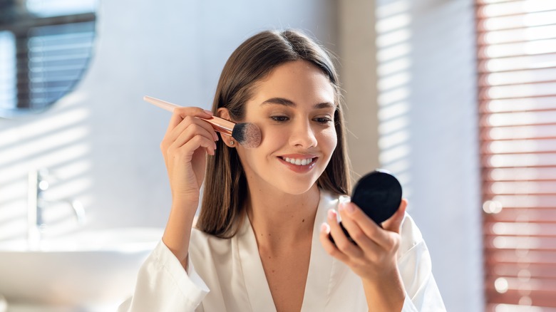 woman using using makeup brush