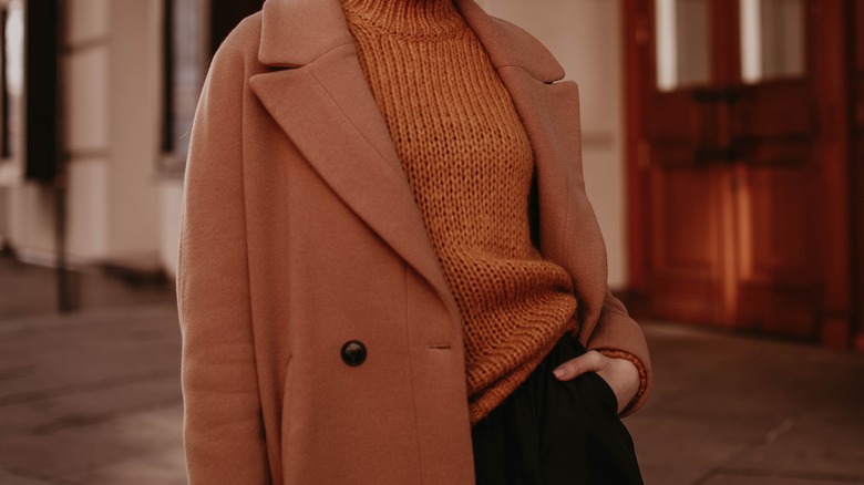 Close up of brown coat and brown knitwear