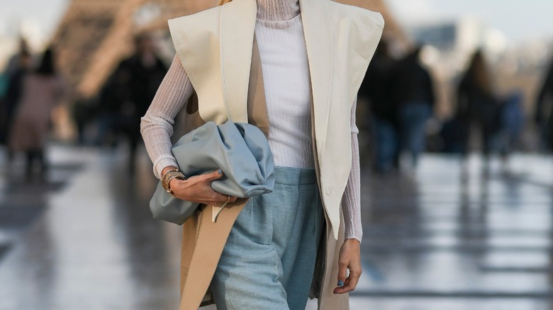 Woman in vest carrying a clutch