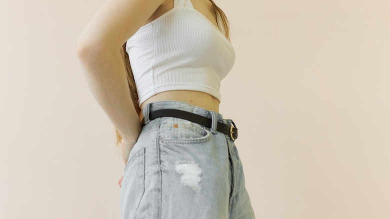 Woman wearing boyfriend jeans and white tank top