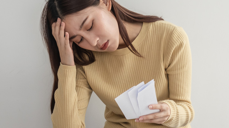 Woman stressed out holding receipts