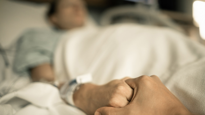 man holding hand of sick person
