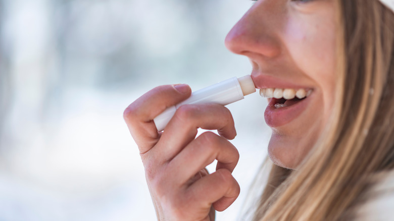 Woman applying lip balm