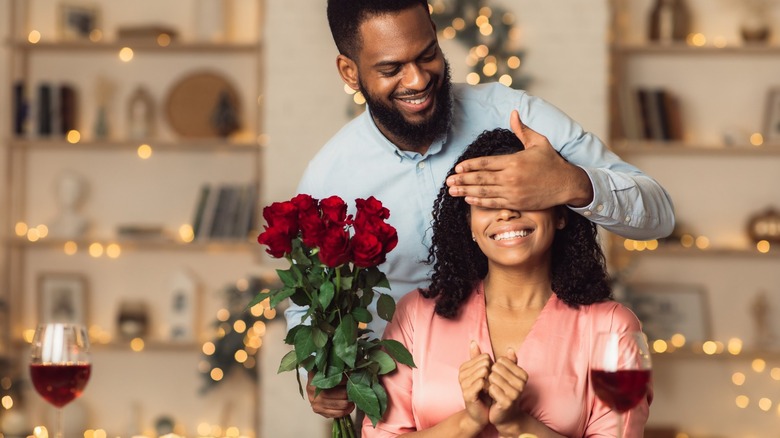 Man surprising girl with flowers