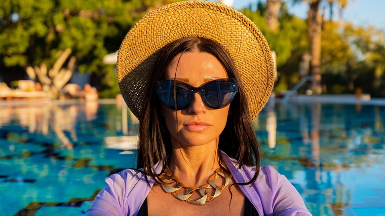 Woman wearing sunglasses, straw hat