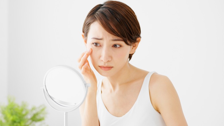 Woman examining dry eye skin