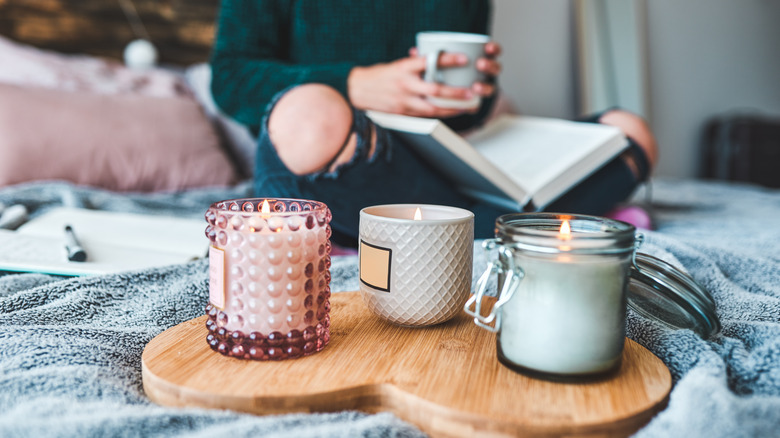 person reading next to lit candles