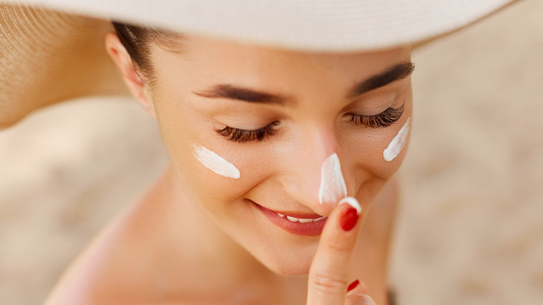 woman dotting sunblock on face