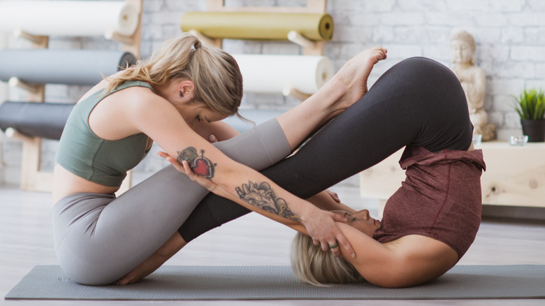 Two women making yin and yang symbol with their bodies