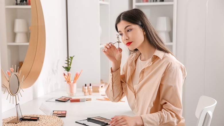 woman using eyelash curler