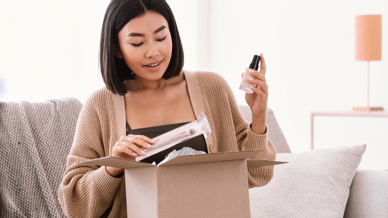 Woman opening box of beauty products