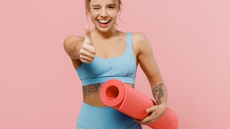 Woman holding exercise mat