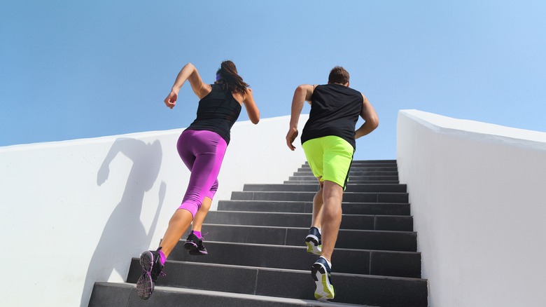 Two people running up stairs