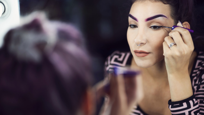 woman applying eyeliner