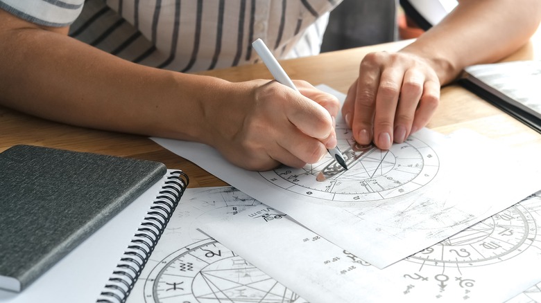 Closeup of hands drawing a natal chart