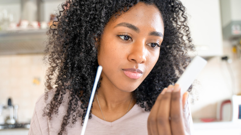 woman looking at covid test results