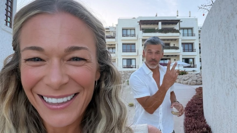 LeAnn Rimes smiles on the front while Eddie Cibrian does the peace sign in the background