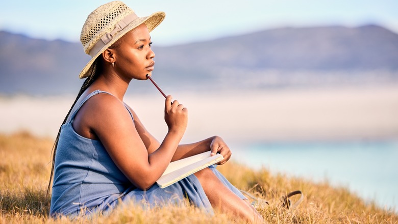 Woman sitting outside, writing journal