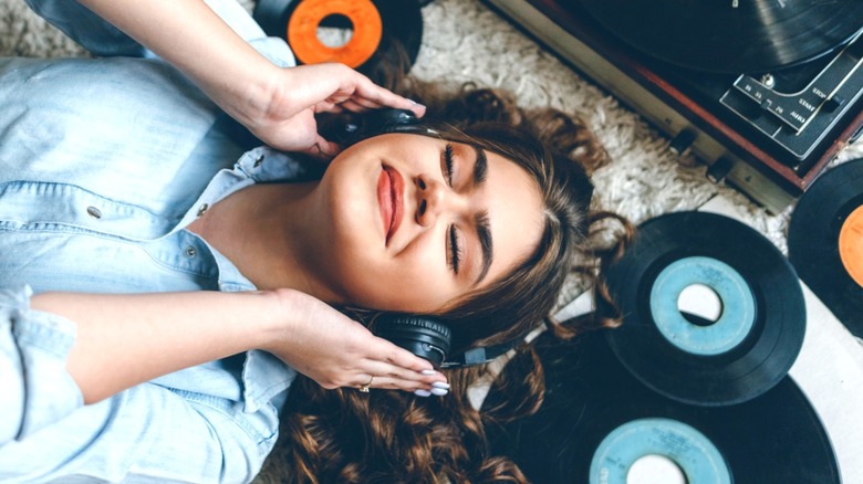 Happy woman listening to vinyl records