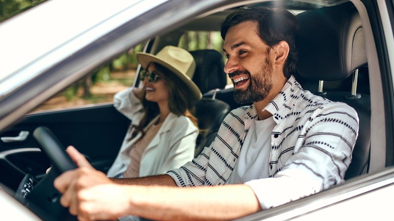 couple driving and smiling